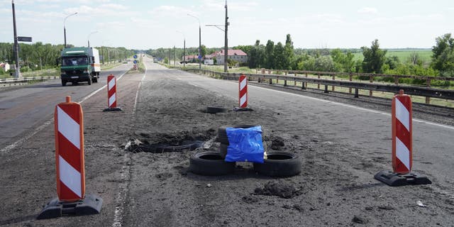 A picture taken July 21, 2022, shows craters on Kherson's Antonovsky Bridge across the Dnieper River caused by a Ukrainian rocket strike during the ongoing Russian military action in Ukraine. 