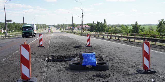 A picture taken July 21, 2022, shows craters on Kherson's Antonovsky Bridge across the Dnieper River caused by a Ukrainian rocket strike during the ongoing Russian military action in Ukraine.