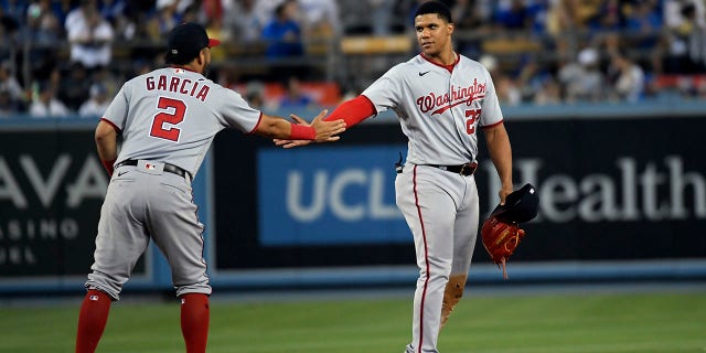 Juan Soto, right, of the Washington Nationals is congratulated by teammate Luis Garcia after hitting a two-run triple against the Los Angeles Dodgers at Dodger Stadium, July 25, 2022, in Los Angeles, California.