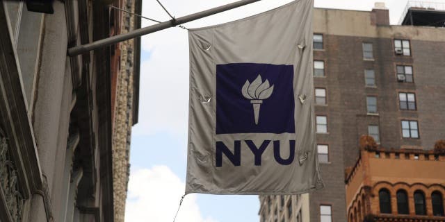 The flag of New York University (NYU) flutters outside the Covid-19 test tent outside the NYU Business School in New York City on August 25, 2020.