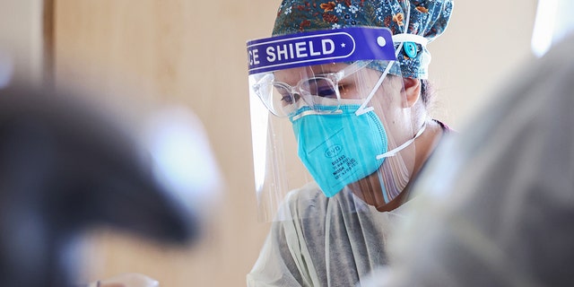 LOS ANGELES, CALIFORNIA - JULY 30:  Registered nurse (RN) Elle Lauron cares for a COVID-19 patient in the improvised COVID-19 unit at Providence Holy Cross Medical Center in the Mission Hills neighborhood on July 30, 2021 in Los Angeles, California.