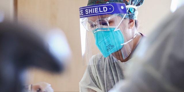LOS ANGELES, CALIFORNIA - JULY 30: Registered nurse (RN) Elle Lauron cares for a COVID-19 patient in the improvised COVID-19 unit at Providence Holy Cross Medical Center in the Mission Hills neighborhood on July 30, 2021 in Los Angeles, California.