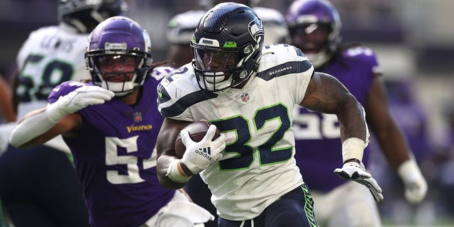 Chris Carson #32 of the Seattle Seahawks runs the ball for a touchdown during the second quarter in the game against the Minnesota Vikings at U.S. Bank Stadium on Sept. 26, 2021 in Minneapolis, Minnesota. 