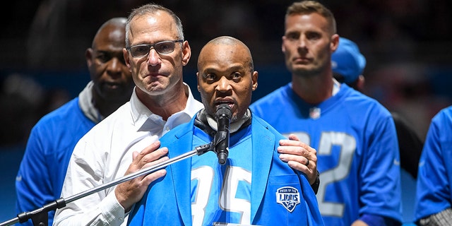 Chris Spielman, left, embraces William White, both former Detroit Lions players, during the Pride of the Lions celebration at halftime in the game against the Philadelphia Eagles at Ford Field in Detroit on Oct. 31, 2021.