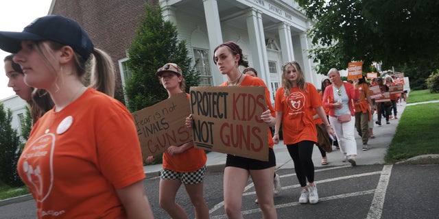 People attend a rally and march for National Gun Violence Awareness Day on June 03, 2022, in Newtown, Connecticut.  Across the nation people are wearing orange and joining rallies as they demand change to America's gun laws. 