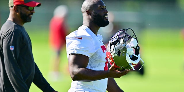 Leonard Fournette #7 of Tampa Bay Buccaneers walks with running backs coach Todd McNair during the 2022 Buccaneers minicamp at AdventHealth Training Center on June 08, 2022 in Tampa, Florida.