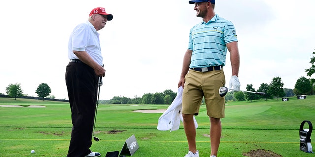 Voormalige Amerikaanse. President Trump talks with team captain Bryson DeChambeau of Crushers GC on the practice range during the pro-am prior to the LIV Golf Invitational - Bedminster at Trump National Golf Club Bedminster on July 28, 2022 in Bedminster, New Jersey. 