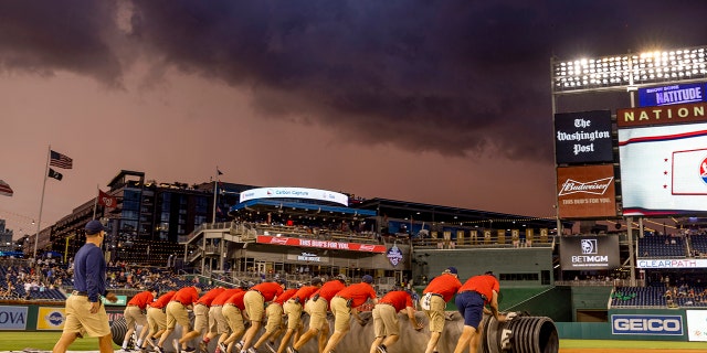 Grounds crews cover the field during the rain delay at the Congressional Baseball Game for Charity at Nationals Park July 28, 2022 at Nationals Park in Washington, D.C.
