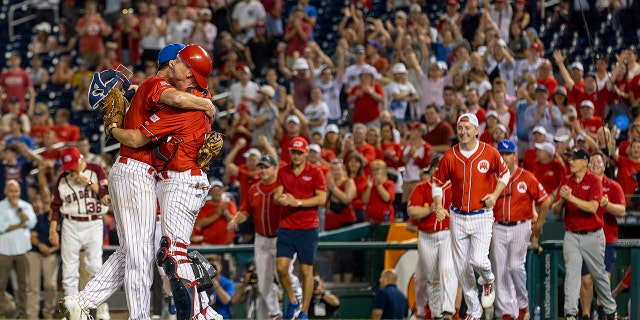 Après le match de baseball du Congrès pour la charité au Nationals Park à Washington, DC le 28 juillet 2022, Rep  August Pfluger (R-TX) et Rep.  Rodney Davis (R-IL) célèbre.  Le jeu bilatéral annuel a été joué pour la première fois en 1909.