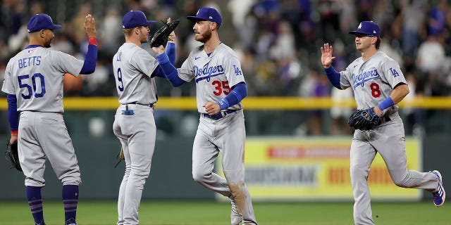 Mookie Betts, #50, Gavin Lux, #9, Cody Bewllinger, #35, and Zach McKinstray, #8 of the Los Angeles Dodgers, celebrate their win against the Colorado Rockies at Coors Field on July 28, 2022 in Denver, Colorado.