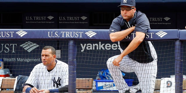 Derek Jeter #2 (R) and Alex Rodriguez #13 of the New York Yankees look on from the dugout in the ninth inning against the Detroit Tigers at Yankee Stadium on August 11, 2013, in the Bronx borough of New York City.