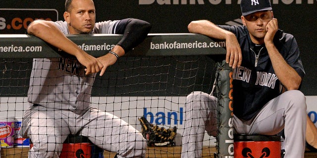 Alex Rodriguez #13 (L) and Derek Jeter #2 of the New York Yankees look on against the Baltimore Orioles in the ninth inning at Oriole Park at Camden Yards on September 11, 2013 in Baltimore, Maryland.