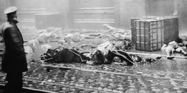 A policeman stands in the street, observing charred rubble and corpses of workers after the Triangle Shirtwaist Company fire in NYC, March 25, 1911. The tragedy inspired Garrett Morgan, a garment-industry entrepreneur in Cleveland, to create a breathing device to aid rescue workers.