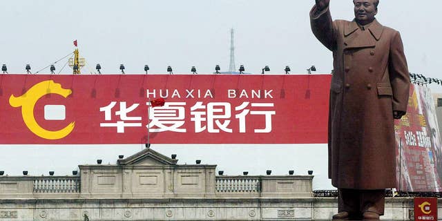 A large statue of Mao Zedong, erected during the height of the Cultural Revolution in 1969, waves from Zhongshan Square in Shenyang, May 2002.