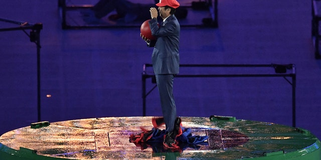 Japanese Prime Minister Shinzo Abe, dressed as Super Mario, holds a red ball during the closing ceremony of the Rio 2016 Olympic Games at the Maracana stadium in Rio de Janeiro on August 21, 2016. 