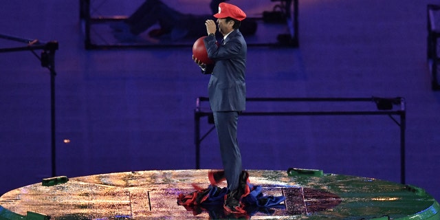 Japanese Prime Minister Shinzo Abe, dressed as Super Mario, holds a red ball during the closing ceremony of the Rio 2016 Olympic Games at the Maracana stadium in Rio de Janeiro on August 21, 2016.