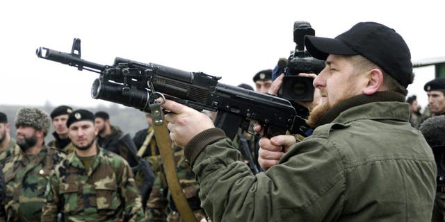 Ramzan Kadyrov proudly displays his shooting skills in front of members of his private army at a firing range in his village of Tsentoroi in Checknya, Russia, in November 2004.