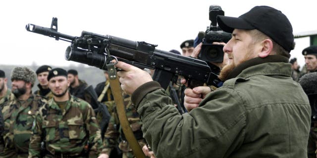 Ramzan Kadyrov proudly displays his shooting skills in front of members of his private army at a firing range in his village of Tsentoroi in Checknya, Russia, in November 2004.