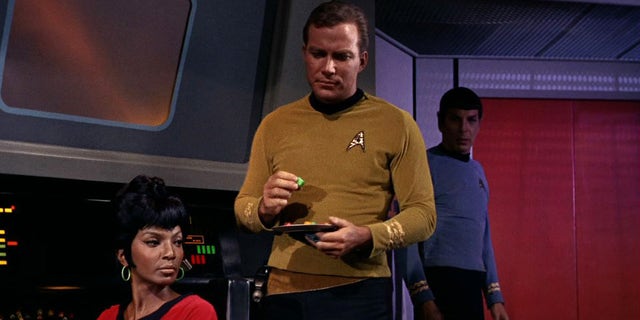Nichelle Nichols (left, as Uhura) and William Shatner (as Captain James T. Kirk) on the bridge of the USS Enterprise in a scene from 