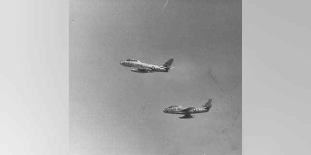 Two F-84 jet fighters, one of the many planes Lamar flew in his three-decade military career, fly overhead in this 1958 foto de archivo. 