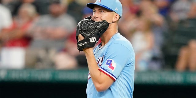 Texas Rangers starting pitcher Glenn Otto bites his glove as he watches the solo home fun by Seattle Mariners' Ty France during the fifth inning of a baseball game in Arlington, Texas, Sunday, July 17, 2022.