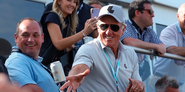 Greg Norman, CEO of LIV Golf, tosses beers to spectators at the 18th green during the Portland Invitational LIV Golf tournament in North Plains, Ore., July 2, 2022. 