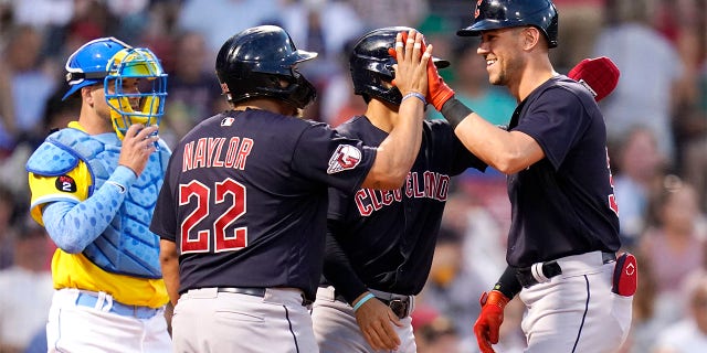 Cleveland Guardians' Nolan Jones, right, is congratulated by Josh Naylor (22) after his three-run home run during the third inning during a baseball game at Fenway Park, Tuesday, July 26, 2022, in Boston. At left is Boston Red Sox catcher Kevin Plawecki, at rear center is Guardians Andres Gimenez.