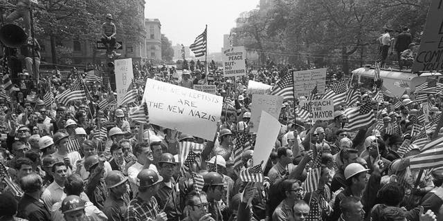 Demonstrators marched with American flags during the Hard Hat Riot in New York City in May 1970. Working-class, pro-American demonstrators clashed with anti-Vietnam War protesters. More than 100 people were injured. 