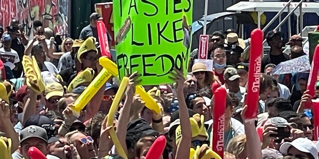 A person holds a sign that reads 
