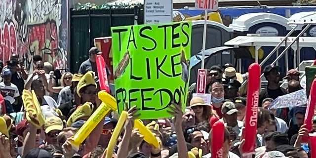 A person holds a sign that reads