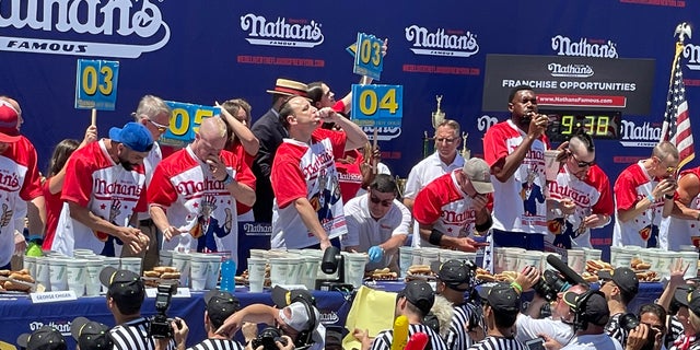 Contestants compete to see who can eat the most hot dogs during Nathan’s Famous Hot Dog Eating Contest at Coney Island on July 4, 2022.