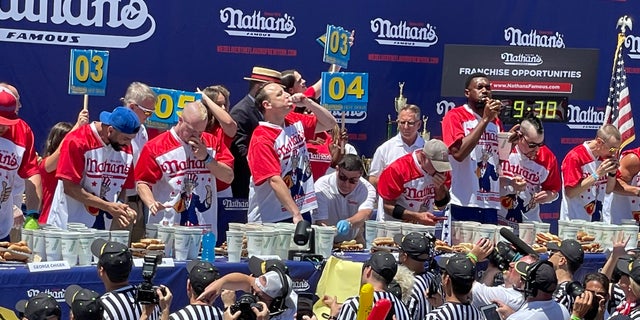 Los concursantes compiten para ver quién puede comer más perritos calientes durante el Concurso de comer perritos calientes famosos de Nathan el 4 de julio de 2022 en Coney Island.