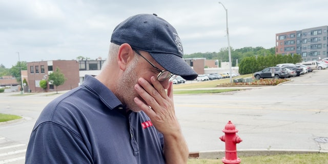 A witness to the Highland Park attack wipes away tears as he recounts the shooting.
