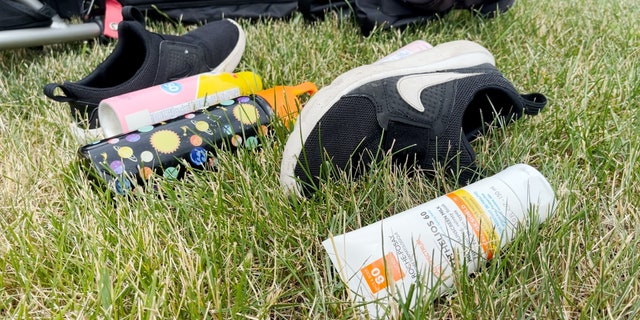 Children's sneakers and sunscreen lay next to lawn chairs left behind following the Highland Park Independence Day parade shooting.