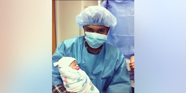 Elijah Muhammad with his newborn son in this undated photo