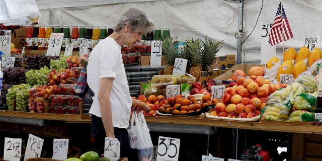 NEW YORK, NEW YORK - 26 JUILLET : Une femme cueille de la nourriture sur un marché de produits frais le 26 juillet 2022 à New York.