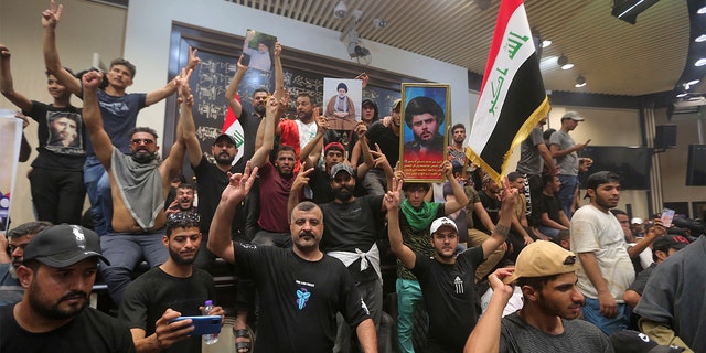 Manifestantes iraquíes exhiben banderas y retratos del clérigo Muqtada al-Sadr dentro del parlamento en Bagdad, Irak, el sábado 30 de julio de 2022. 