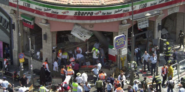 Police and medics surround the scene of a bomb explosion in a restaurant downtown Jerusalem, Aug. 9, 2001.  (AP Photo/Peter Dejong)