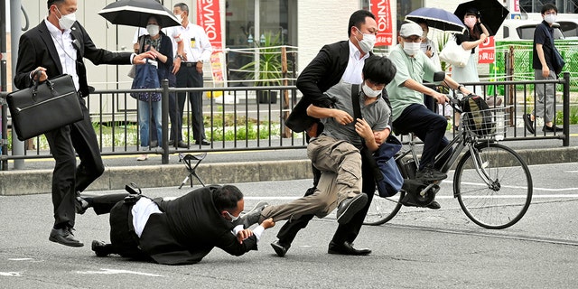 In this photo taken by the Asahi Shimbun, a man believed to have shot former Japanese Prime Minister Shinzo Abe was attacked by a police officer in Nara on July 8, 2022. 