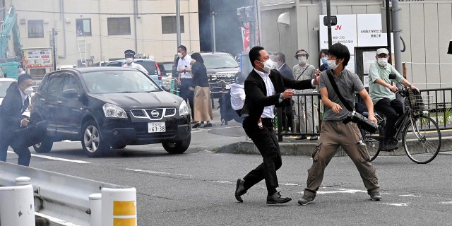 A police officer detains a man, believed to have shot former Japanese Prime Minister Shinzo Abe, in Nara, western Japan July 8, 2022.