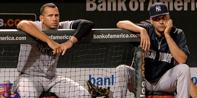 Alex Rodriguez, #13 (L), and Derek Jeter, #2 of the New York Yankees, look on against the Baltimore Orioles in the ninth inning at Oriole Park at Camden Yards on September 11, 2013 in Baltimore, Maryland.