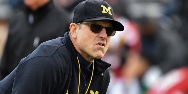 Michigan Wolverines head coach Jim Harbaugh looks on during pre-game warm-ups before an NCAA college football game against the Maryland Terrapins.