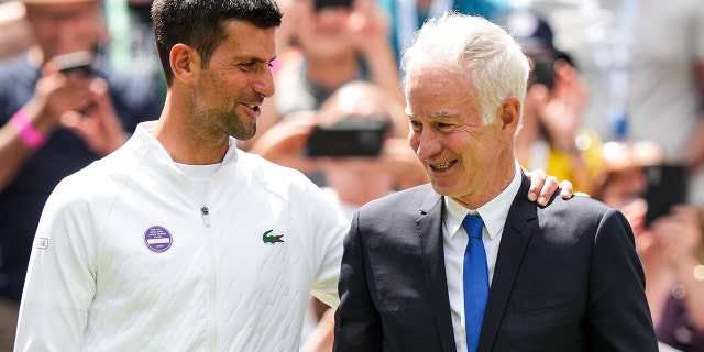 Novak Djokovic of Serbia, left, greets John McEnroe at the Centre Court Centenary Celebration during Wimbledon 2022 at the All England Lawn Tennis and Croquet Club July 3, 2022, in London. 