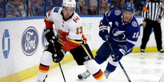 Calgary Flames left wing Johnny Gaudreau (13) carries the puck past Tampa Bay Lightning left wing Ondrej Palat (18) during the third period of an NHL hockey game, Jan. 11, 2018, in Tampa, Fla. Executives around the NHL expect plenty of movement before free agency opens Wednesday, July 13, 2022. Several top players including Gaudreau and Palat could still sign contracts prior to hitting the open market.