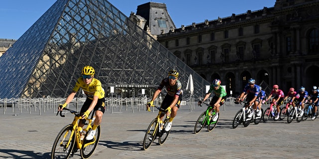 The pack with Denmark's Jonas Vingegaard, wearing the overall leader's yellow jersey, passes the Louvre Museum during the twenty-first stage of the Tour de France cycling race over 116 킬로미터 (72 마일) with start in Paris la Defense Arena and finish on the Champs Elysees in Paris, 프랑스, 일요일, 칠월 24, 2022. 