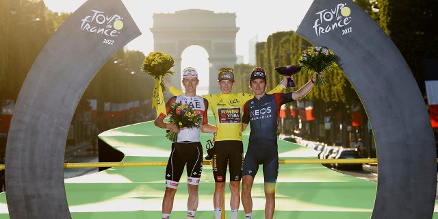 Tour de France winner Denmark's Jonas Vingegaard, wearing the overall leader's yellow jersey, second place Slovenia's Tadej Pogacar, left, and third place Britain's Geraint Thomas, celebrate on the podium after the twenty-first stage of the Tour de France cycling race over 116 kilometers (72 miles) with start in Paris la Defense Arena and finish on the Champs Elysees in Paris, France, Sunday, July 24, 2022.