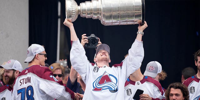 Colorado Avalanche defenseman Josh Manson lifts the Stanley Cup during a rally outside the City/County Building for the NHL hockey champions after a parade through the streets of downtown Denver, Thursday, June 30, 2022. 