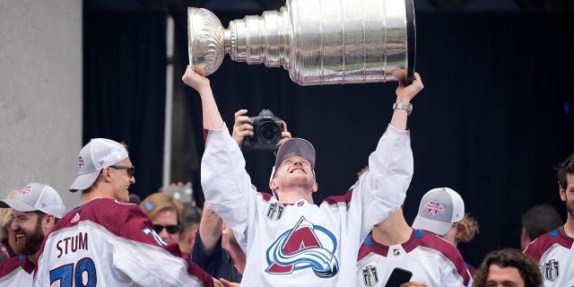 Colorado Avalanche defenseman Josh Manson raises the Stanley Cup during a rally outside the City/County Building honoring NHL hockey champions after a parade through the streets of downtown Denver, Thursday, June 30, 2022.