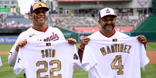 Washington Nationals right fielder Juan Soto (22) and manager Dave Martinez (4) pose with their All-Star jerseys before a baseball game against the Atlanta Braves, Sunday, July 17, 2022, in Washington. 