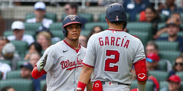 The Washington Nationals' Juan Soto, left, celebrates after scoring with Luis Garcia (2) in a game against the Atlanta Braves at Truist Park July 9, 2022, in Atlanta. 